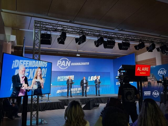 El set montado en las oficinas estatales del PAN para el foro de los «no-precandidatos» por León. El letrero «Al aire · Silencio» completa la puesta en escena.