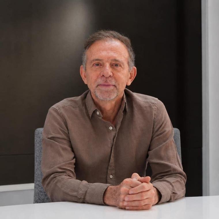 Retrato de un hombre sentado a una mesa.