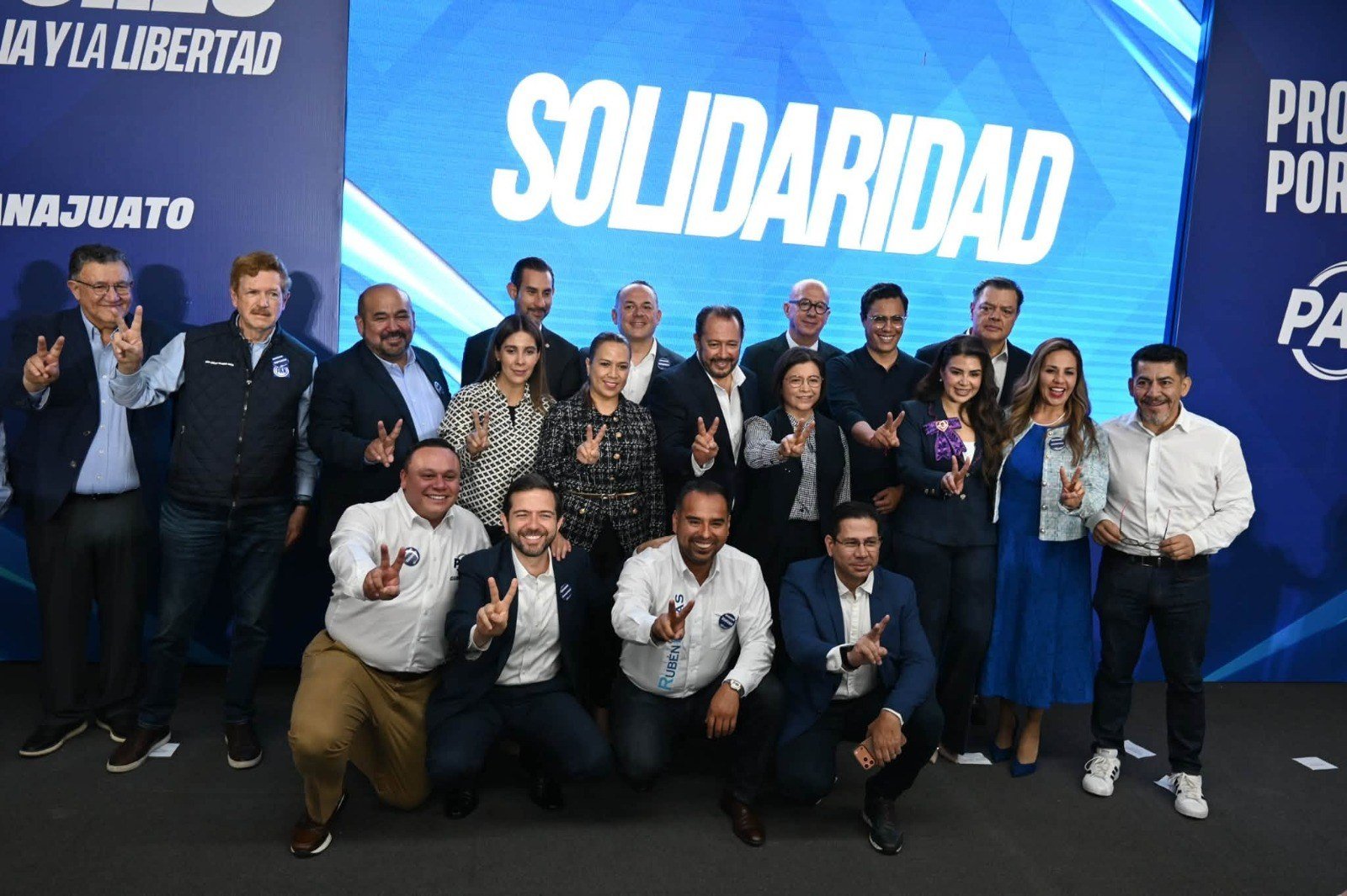Foto de grupo en el escenario del PAN Guanajuato, frente a una pantalla con la palabra «Solidaridad», al término de la toma de protesta.