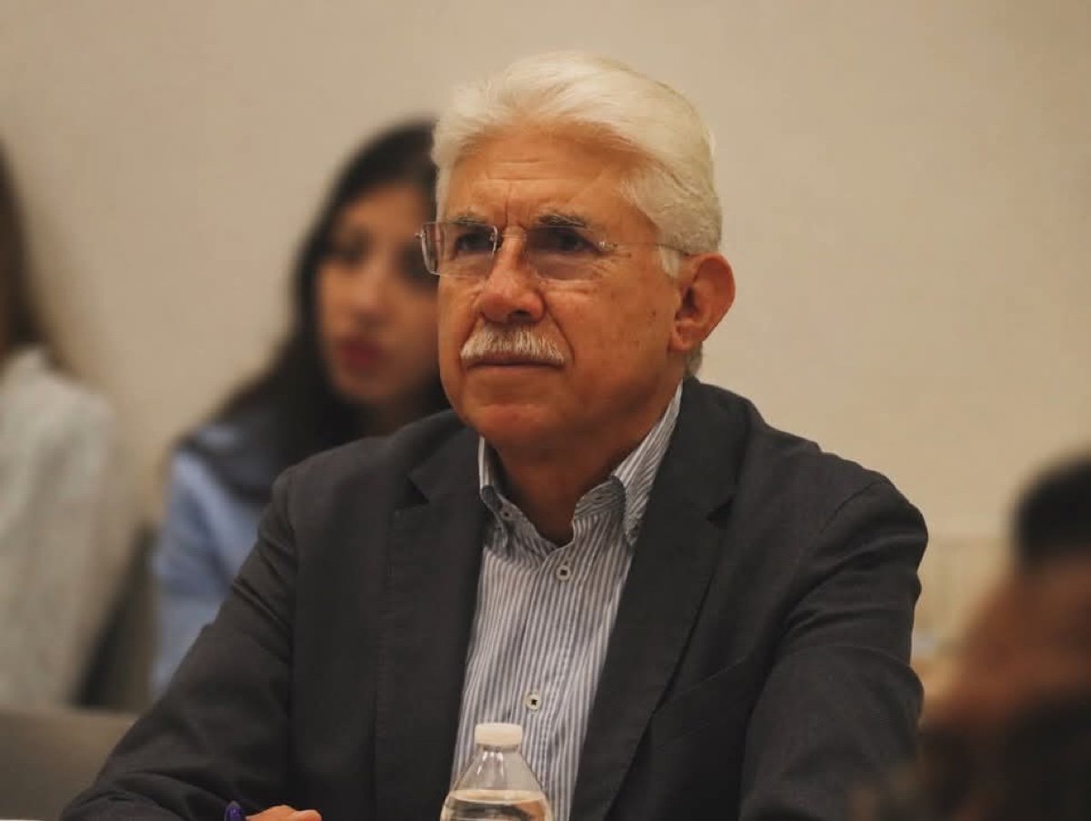 Luis Ernesto Ayala Torres, sentado y atento durante una reunión
