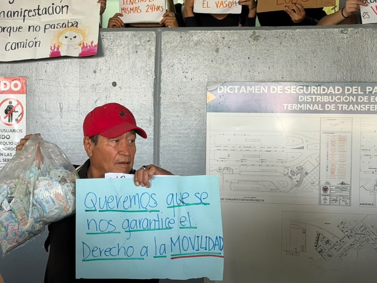 Un usuario del SIT sostiene una bolsa llena de boletos y una pancarta que pide garantizar el derecho a la movilidad