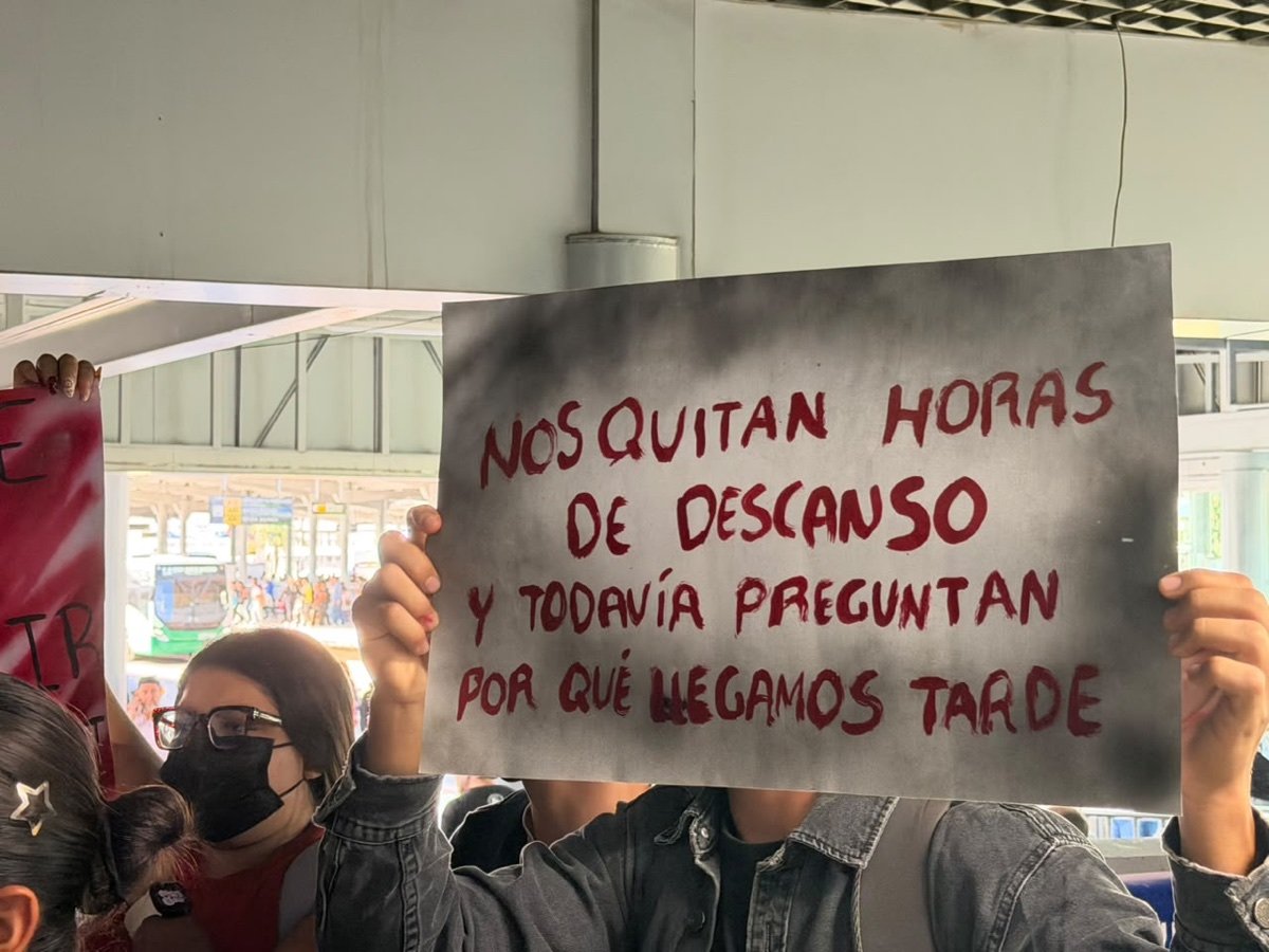 Pancarta con la leyenda «Nos quitan horas de descanso y todavía preguntan por qué llegamos tarde»