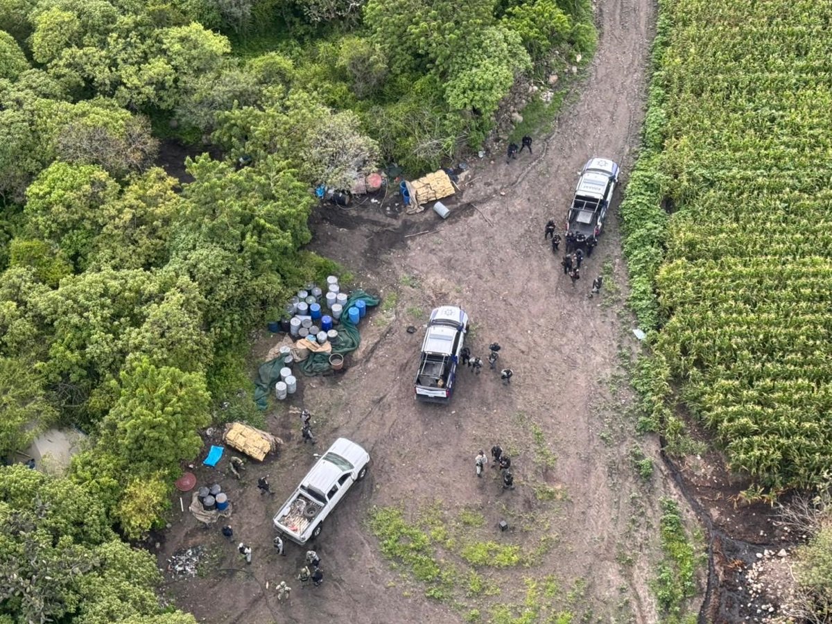 Vista aérea del operativo en Iramuco: patrullas, tambos y personal desplegado en una brecha entre el monte y una parcela de maíz.