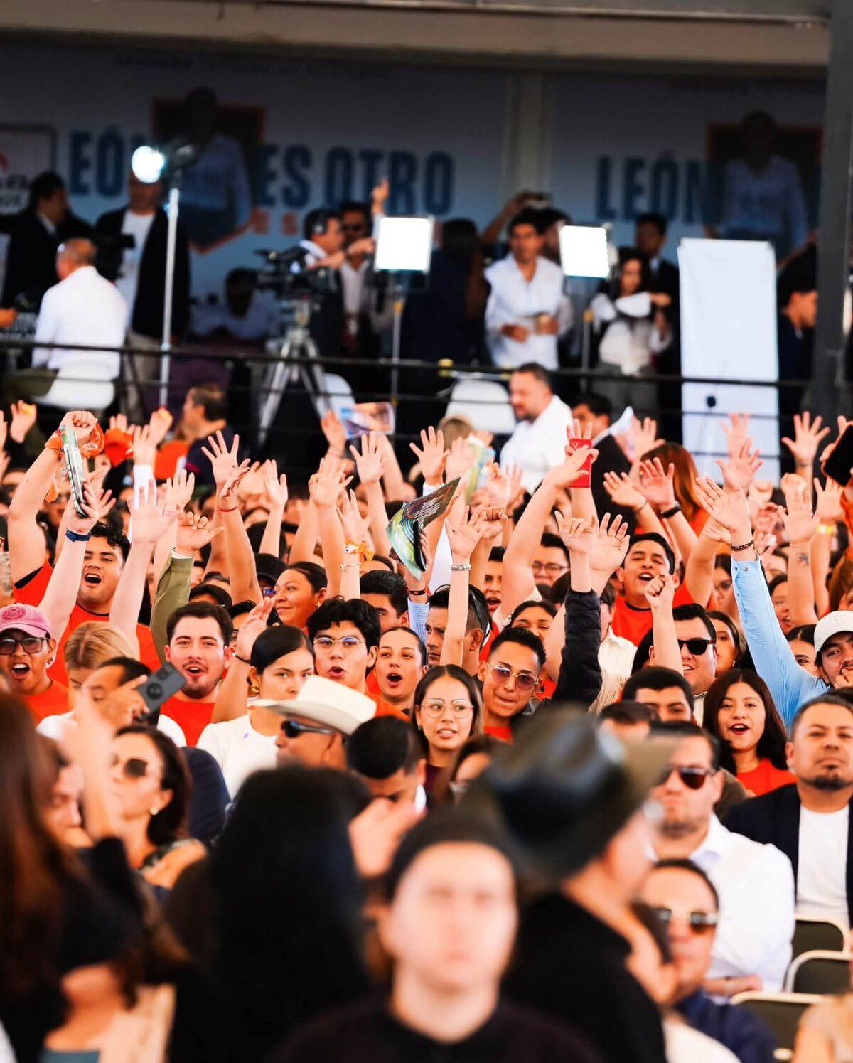 El público de pie en la Velaria de la Feria, frente al escenario con la leyenda «León es otro»
