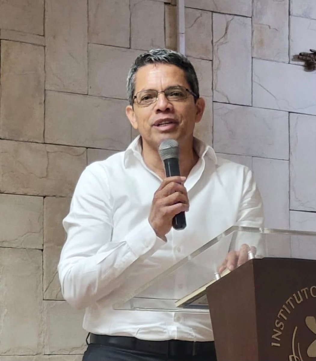 Alberto Cifuentes Negrete habla en un atril con micrófono.